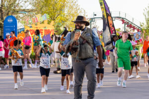 Grand opening day featured a playful processional including a newly hatched baby dinosaur. Guests have the chance to meet the baby dinosaur in Jurassic World Adventure Camp. 